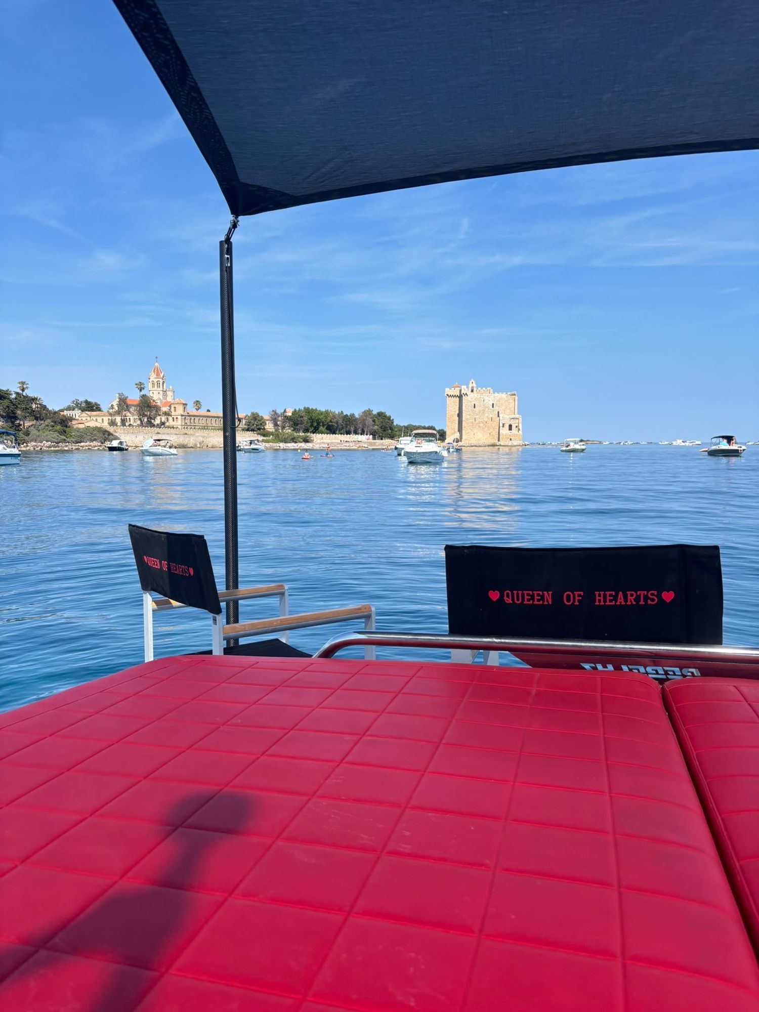 The fortified monastery of Saint-Honorat seen from under the shade sail, Queen of Hearts chairs on deck