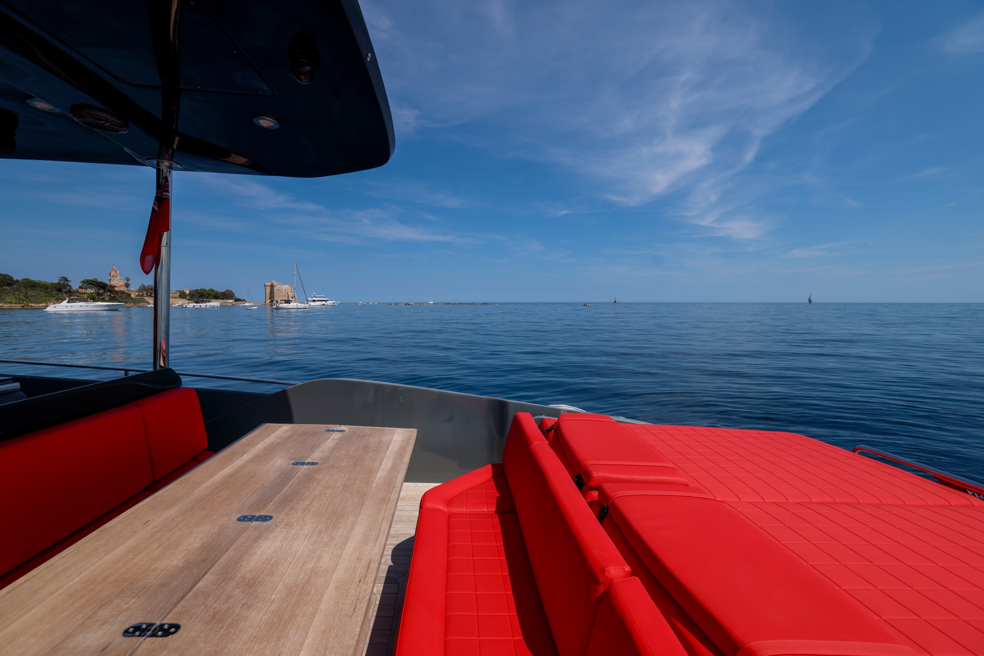 The cockpit of Queen of Hearts under her flag, a towered old town on the horizon