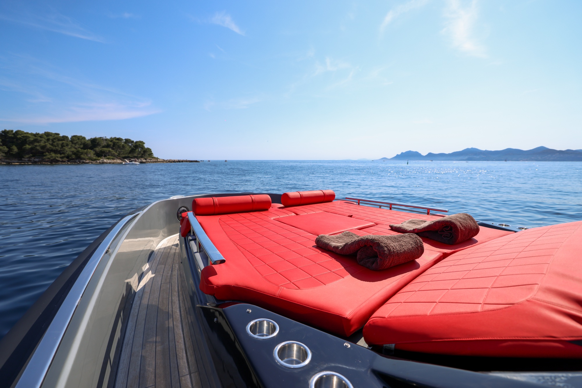 The bow of Queen of Hearts on the open Riviera, islands to port